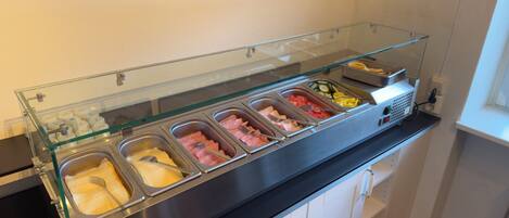 A buffet with various food options, including meats, cheeses, and vegetables.