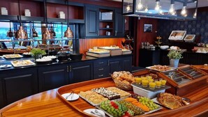 Un bufé de desayuno con diferentes opciones de comida y una estación de café.