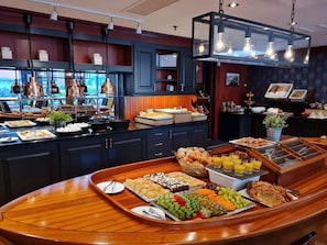 A breakfast buffet with various food items and a coffee station.