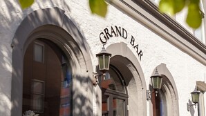 A building facade with the sign "GRAND BAR" and arched windows. - Grand Hotel Arendal - Unike Hoteller (Arendal)