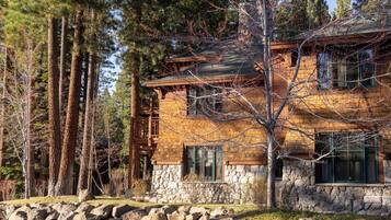 Un chalet rustique aux murs de pierre, aux poutres en bois et à l’escalier en pierre.