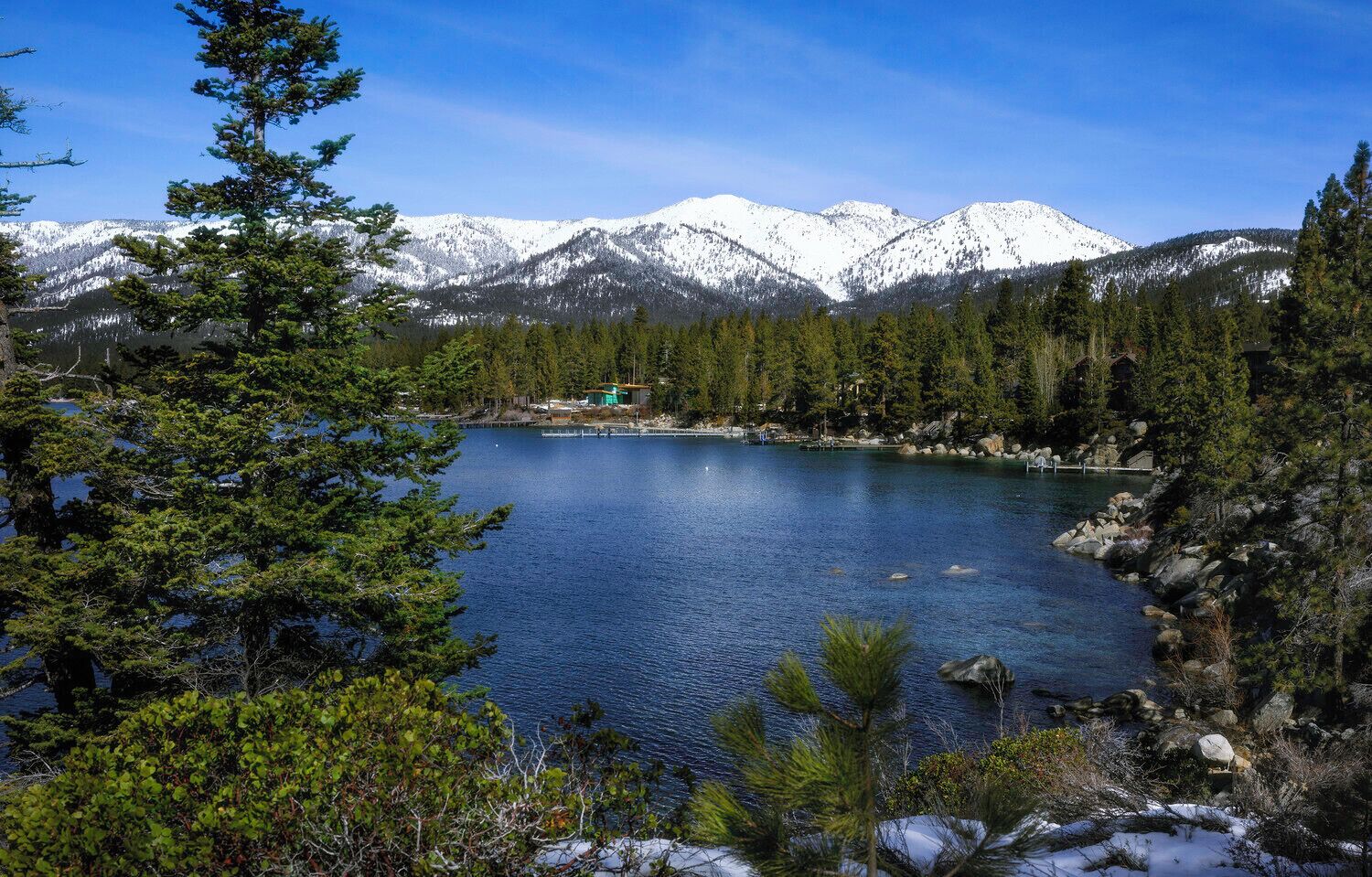 Un lago rodeado de montañas y un denso bosque.