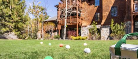 A grassy area with golf balls and a bag with 'BOCCE' text.