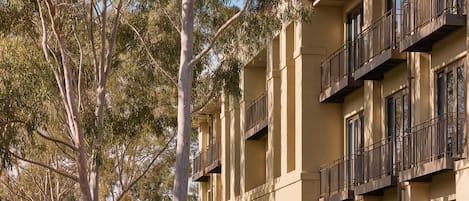 A multi-story building with balconies and large windows.