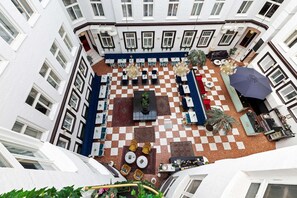 A courtyard with checkered flooring, outdoor seating, and a central table. - Best Western Hotel Bentleys (Stockholm)