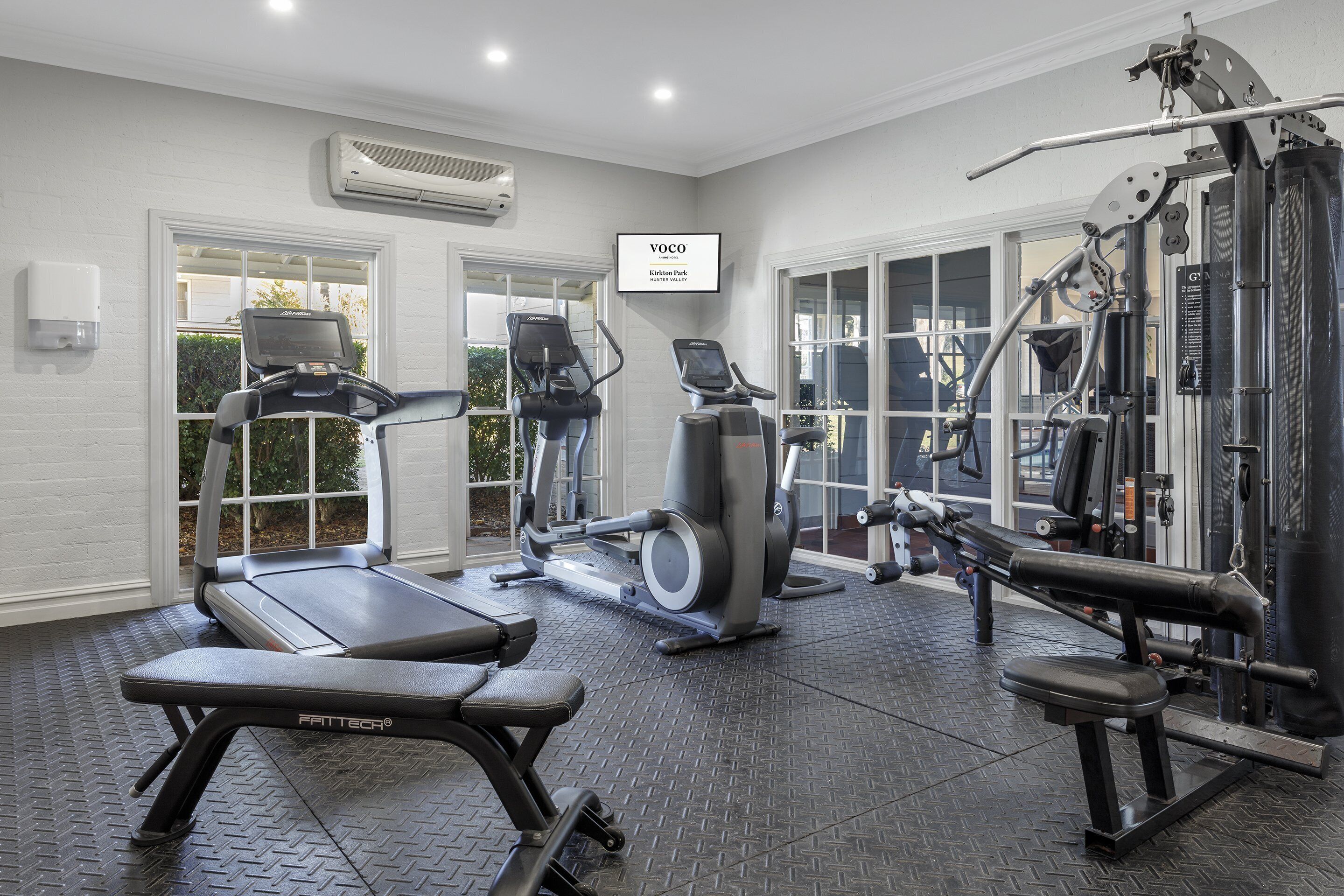 A gym with treadmills, elliptical machines, and weightlifting equipment.