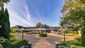 Stunning hotel entrance with a central garden and fountain, flanked by covered walkways.