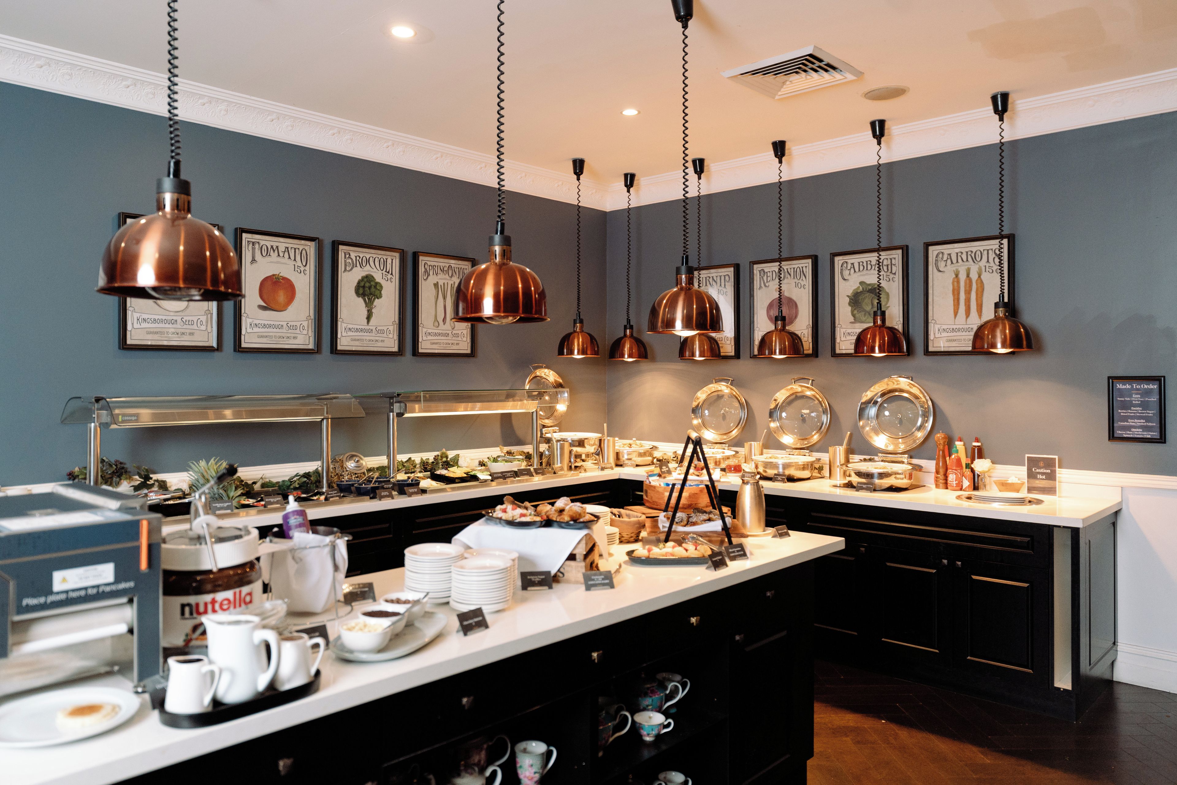 Uma área de buffet com diversos alimentos e um espaço para café.