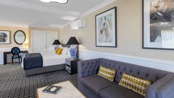 A hotel room with a bed, a sofa, a desk, and a chair.