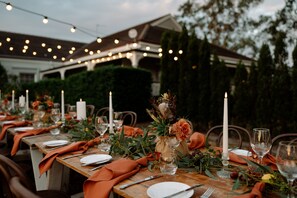 A long dining table set outdoors with candles, glassware, and greenery. - voco Kirkton Park Hunter Valley  by IHG (Pokolbin)
