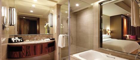 Un baño moderno con ducha de vidrio, un espejo grande y una bañera.