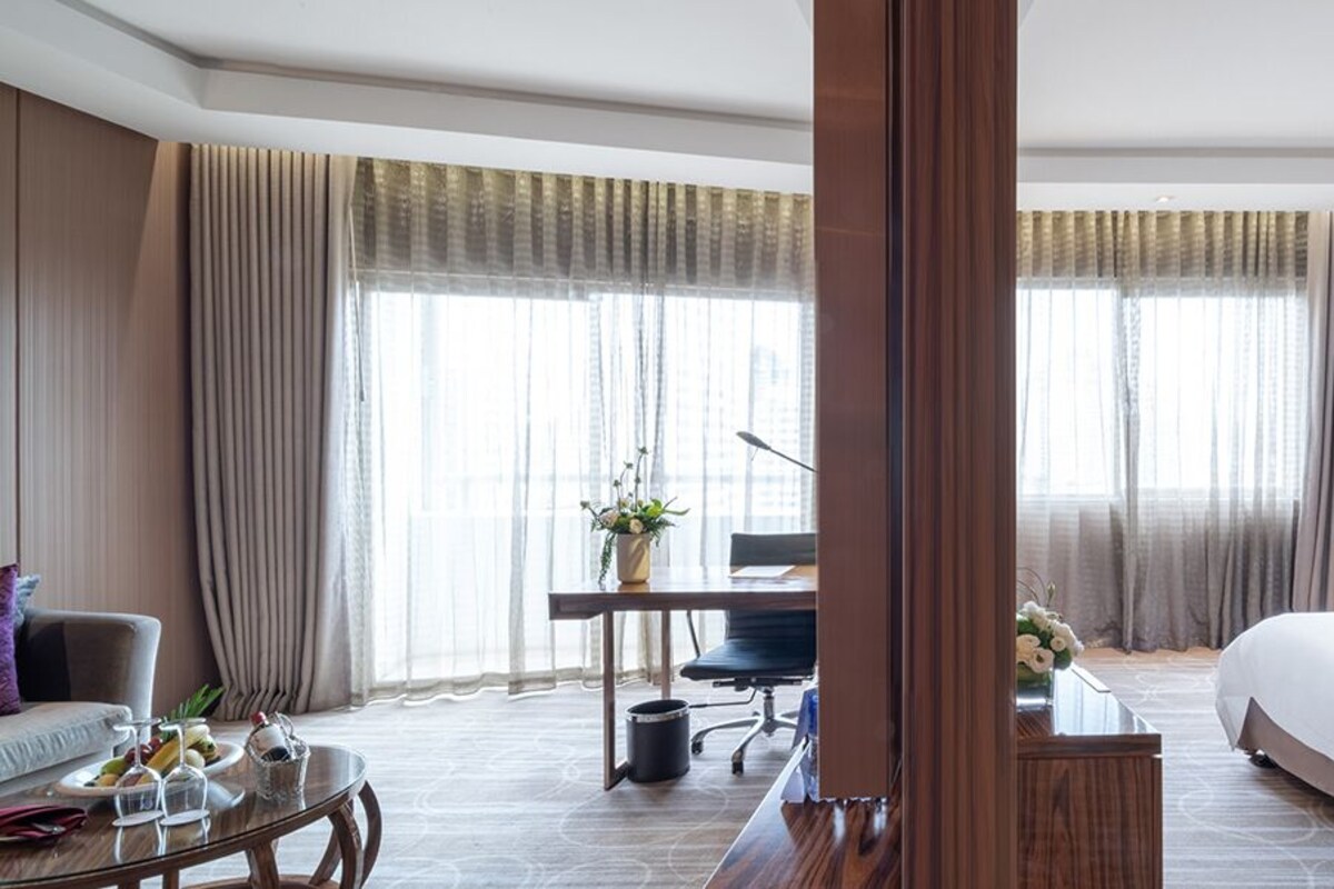 Una habitación de hotel con una cama grande, un escritorio, una silla y un sofá.