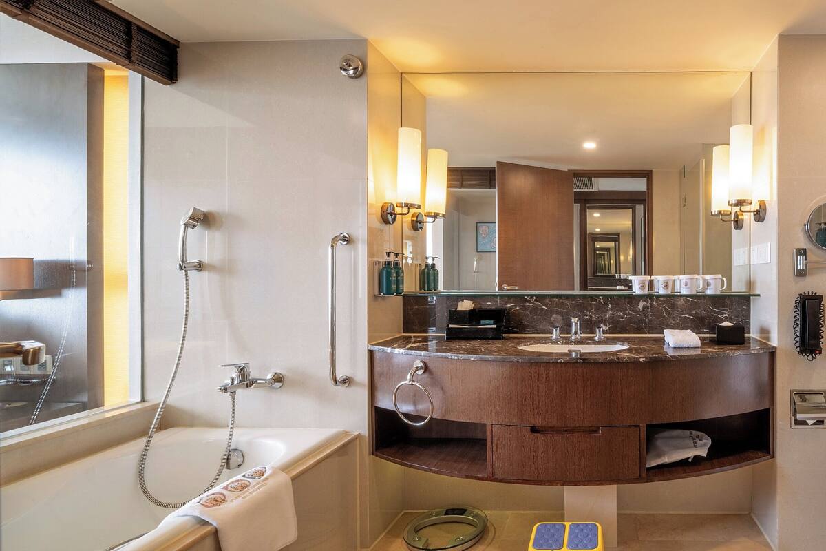 Un baño moderno con bañera, tocador con espejo y zona de ducha.