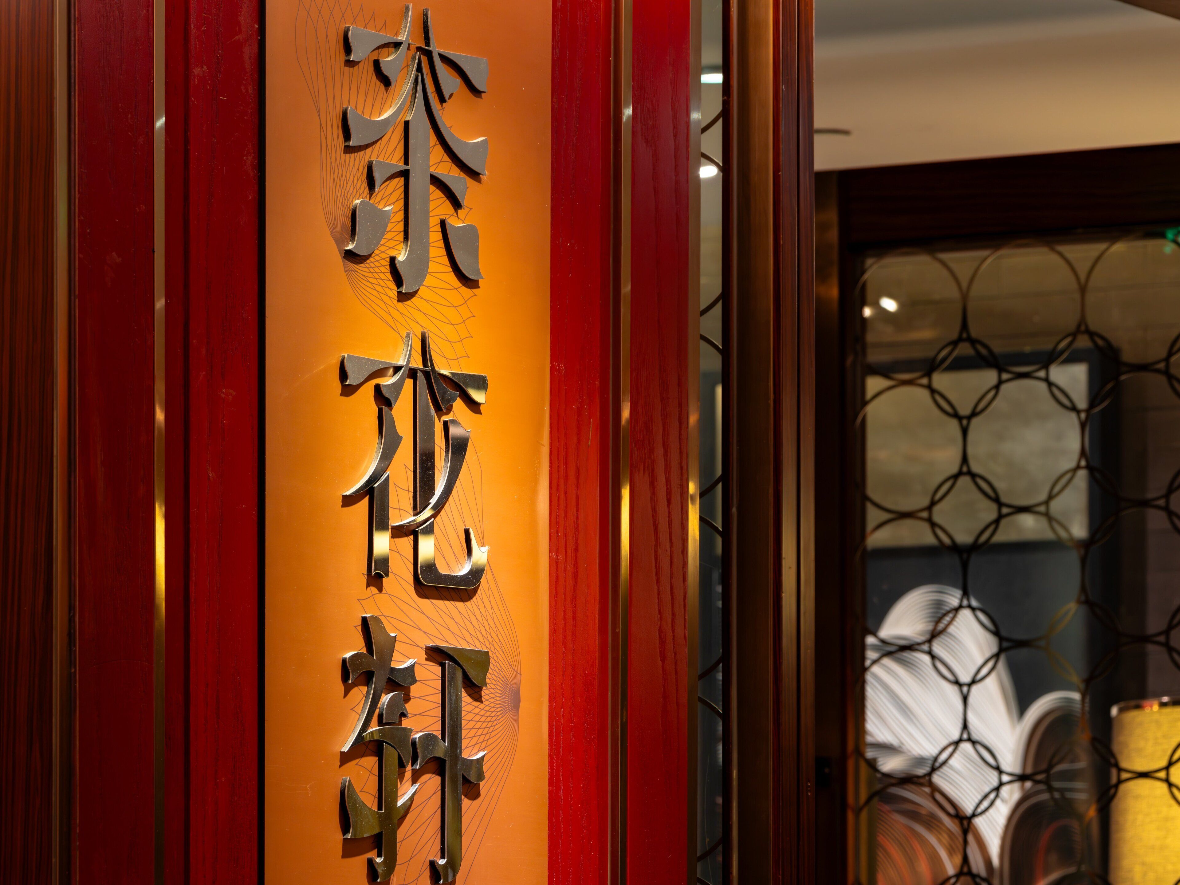 Un letrero vertical con caracteres chinos, probablemente indicando el nombre de un hotel o establecimiento.