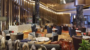 A spacious lobby with high ceilings, modern furniture, and a central staircase. - Crowne Plaza Kunming City Centre by IHG (Kunming)