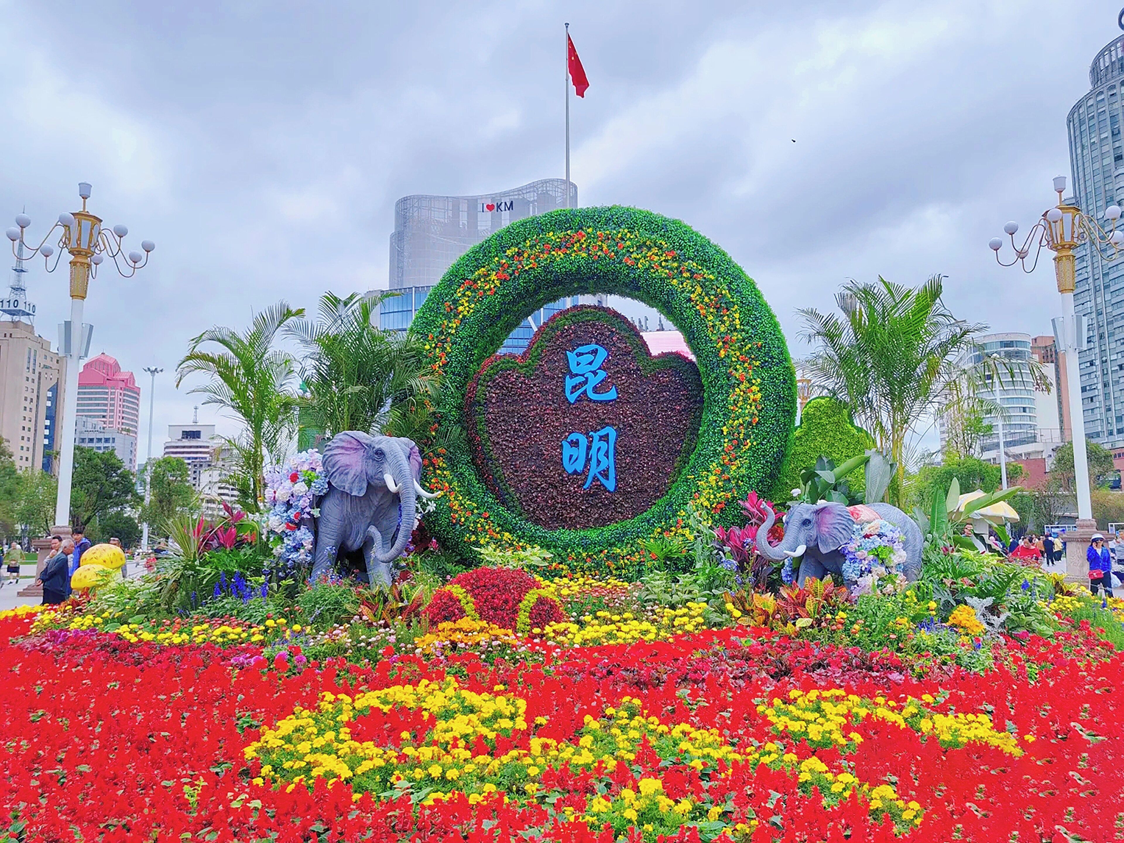 A large floral arrangement with two elephants and a heart-shaped design, surrounded by colorful flowers and palm trees.