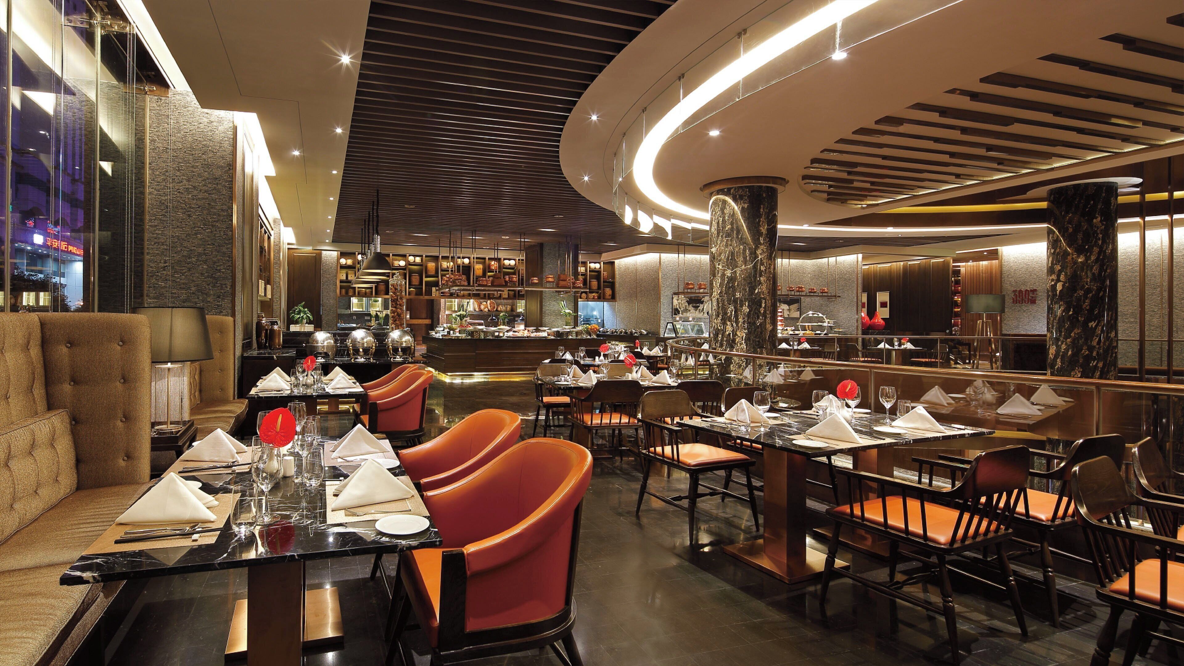 A restaurant with multiple dining tables, chairs, and a bar area.