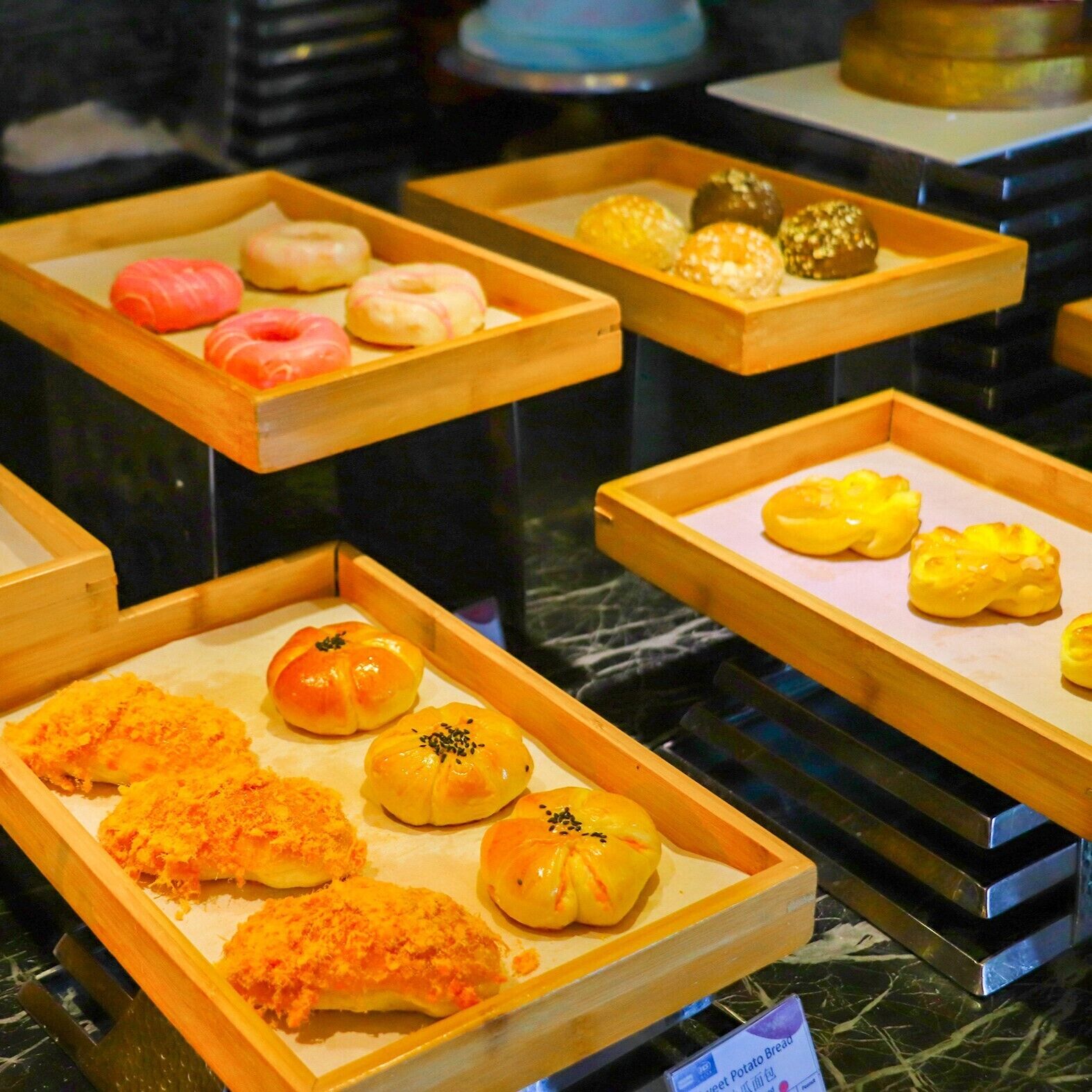 A display of various baked goods in wooden trays.