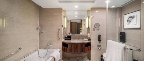 A modern bathroom with a bathtub, a shower, a vanity with a sink, and a toilet.