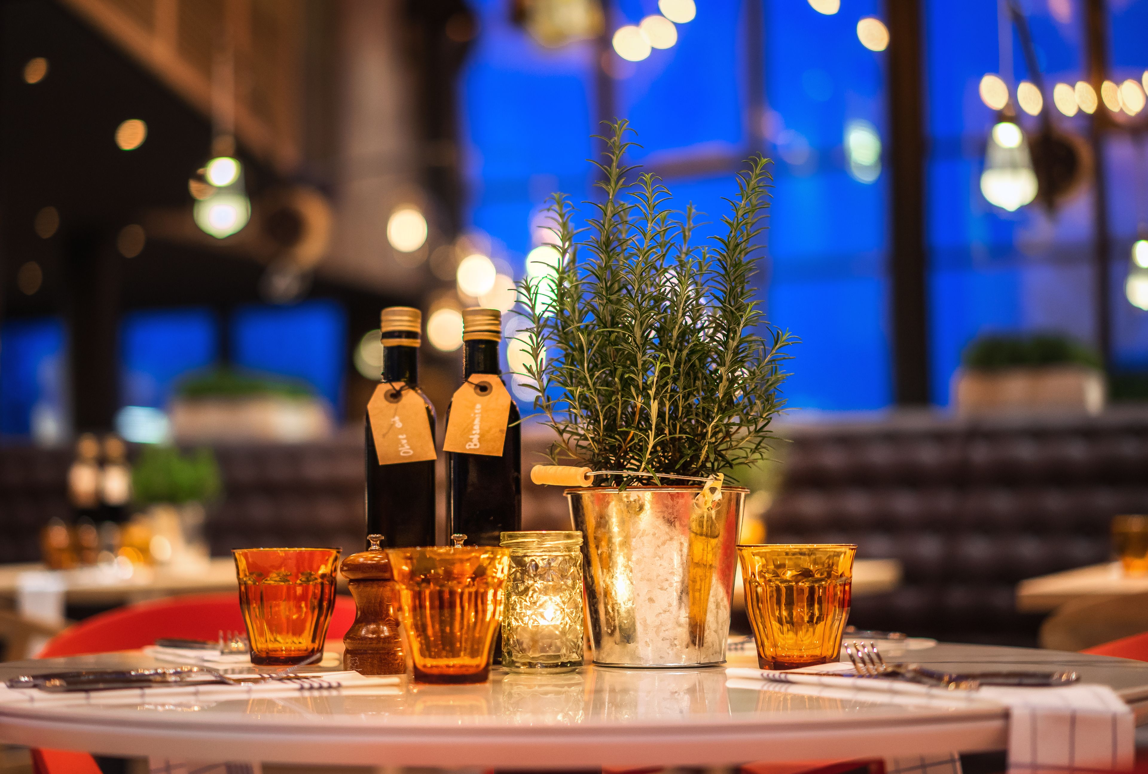 Una mesa de comedor con una planta en maceta, botellas y vasos.