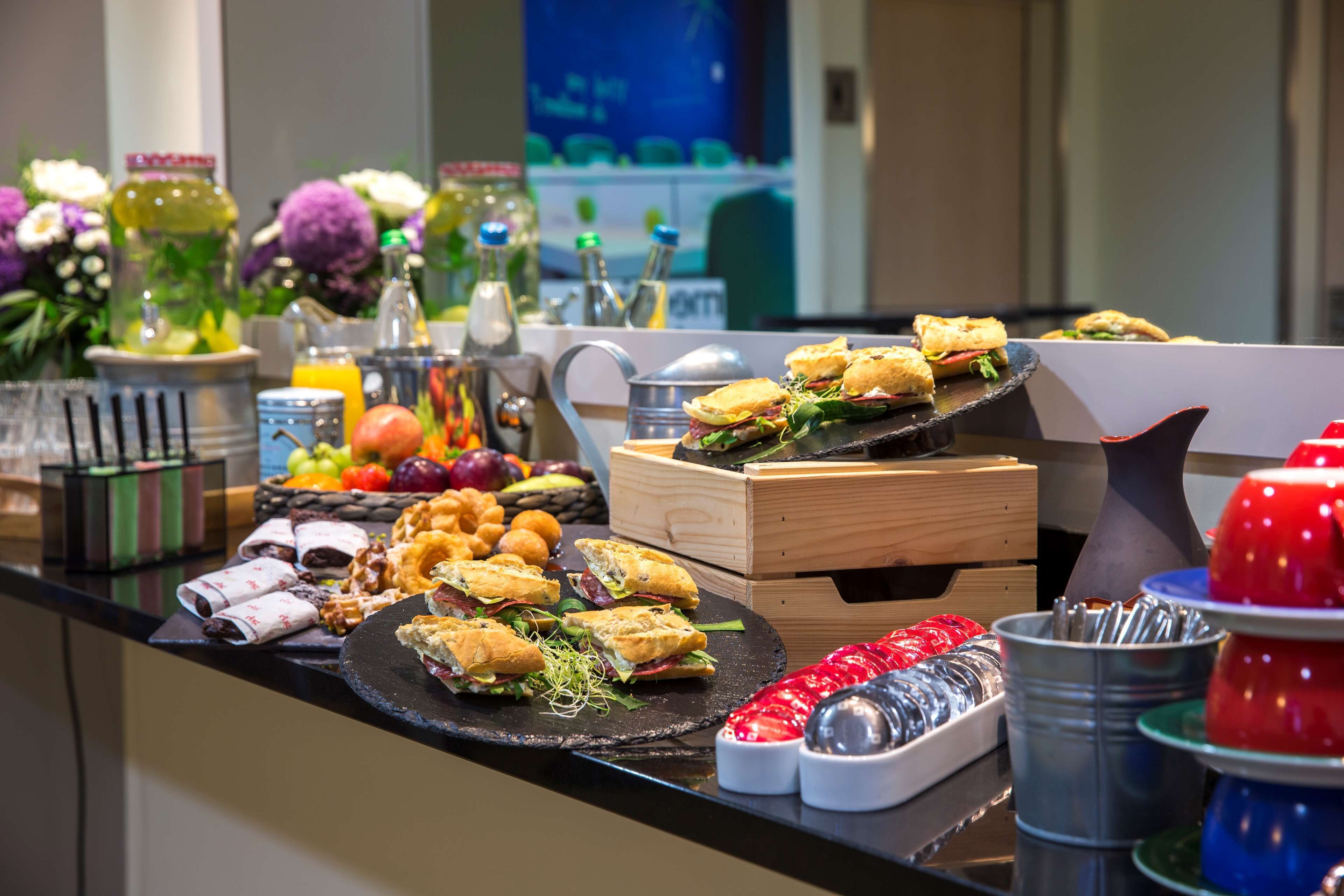 A buffet with sandwiches, fruits, and condiments.