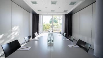 Ein Konferenzraum mit einem langen Tisch, Stühlen und Blick durch große Fenster.