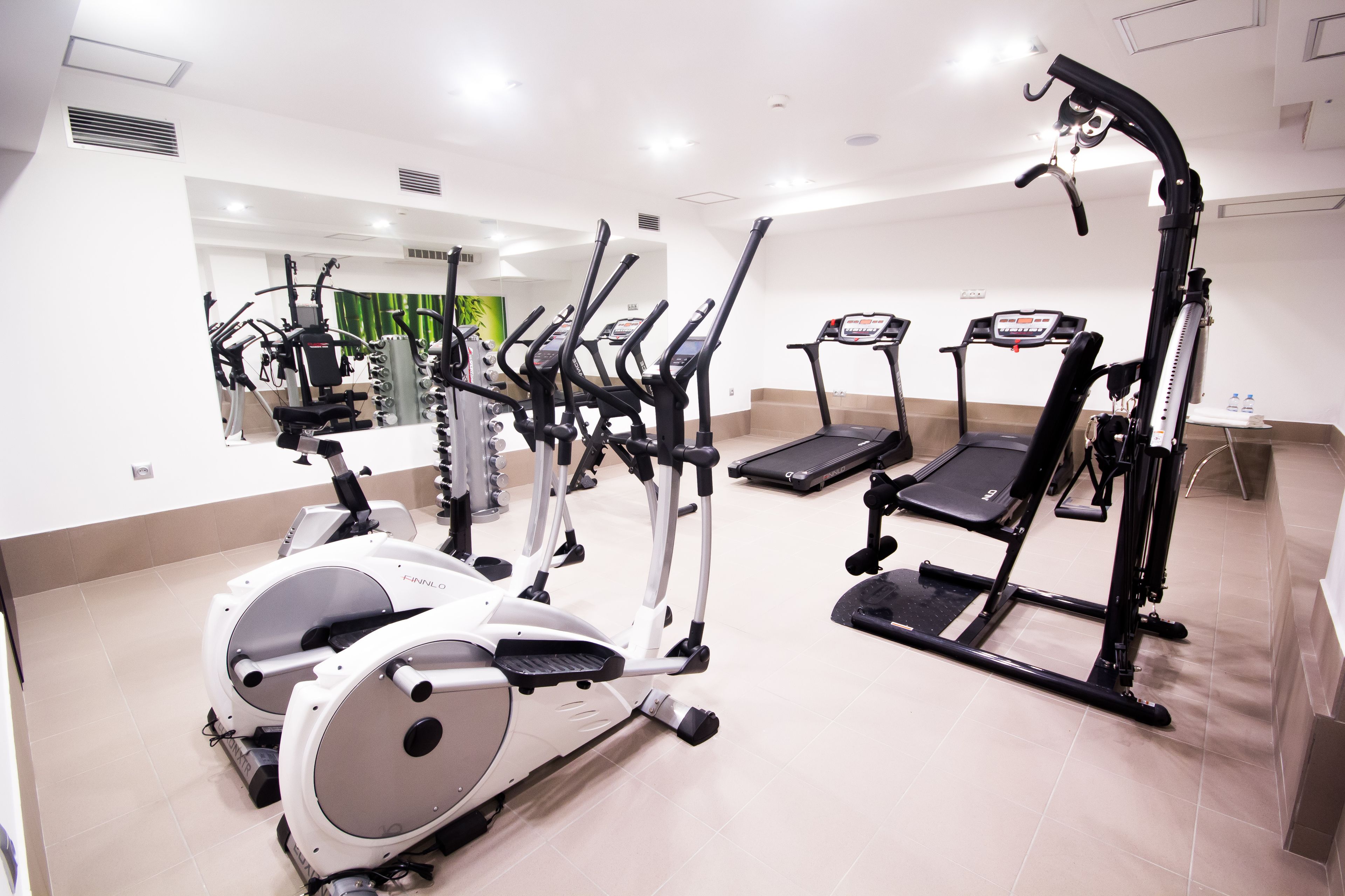 A gym with various cardio machines, including treadmills and elliptical trainers.