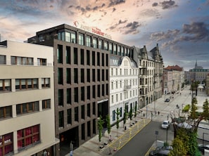 Un hotel con fachada moderna, varios balcones y un letrero llamativo.