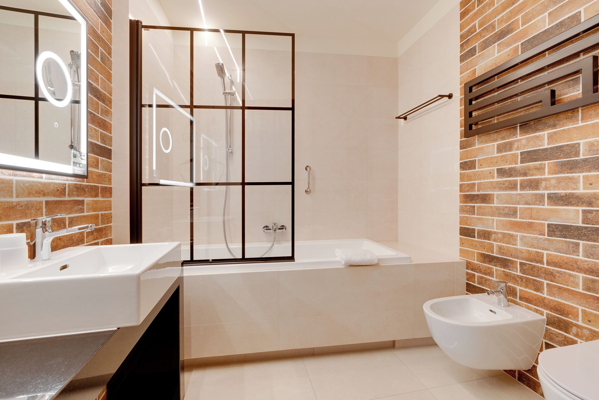 Une salle de bain moderne dotée d’une grande baignoire, d’un lavabo séparé et d’un bidet.