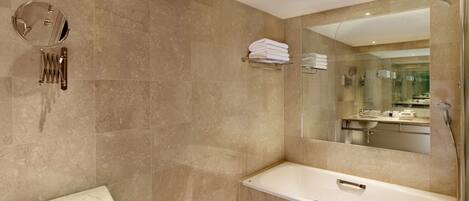 A modern bathroom with a large mirror, a sink, and a shower.