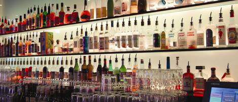 A bar with multiple shelves of liquor bottles and glasses.