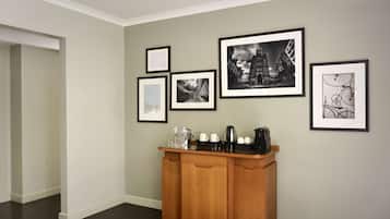 A hallway with a wooden console table and framed black and white photographs on the wall.
