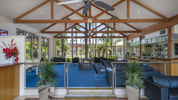 Un vestíbulo amplio con piscina, zona de estar y bar.