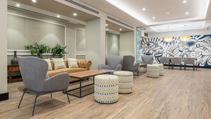 A modern lounge area with seating, a coffee table, and a decorative wall mural. - Hotel LIVVO Fataga (Las Palmas de Gran Canaria)