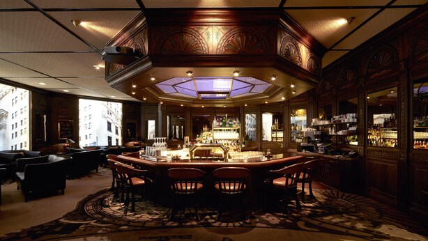 A bar area with a central bar, multiple seating options, and a patterned carpet. - Parkhotel Gütersloh (Guetersloh)