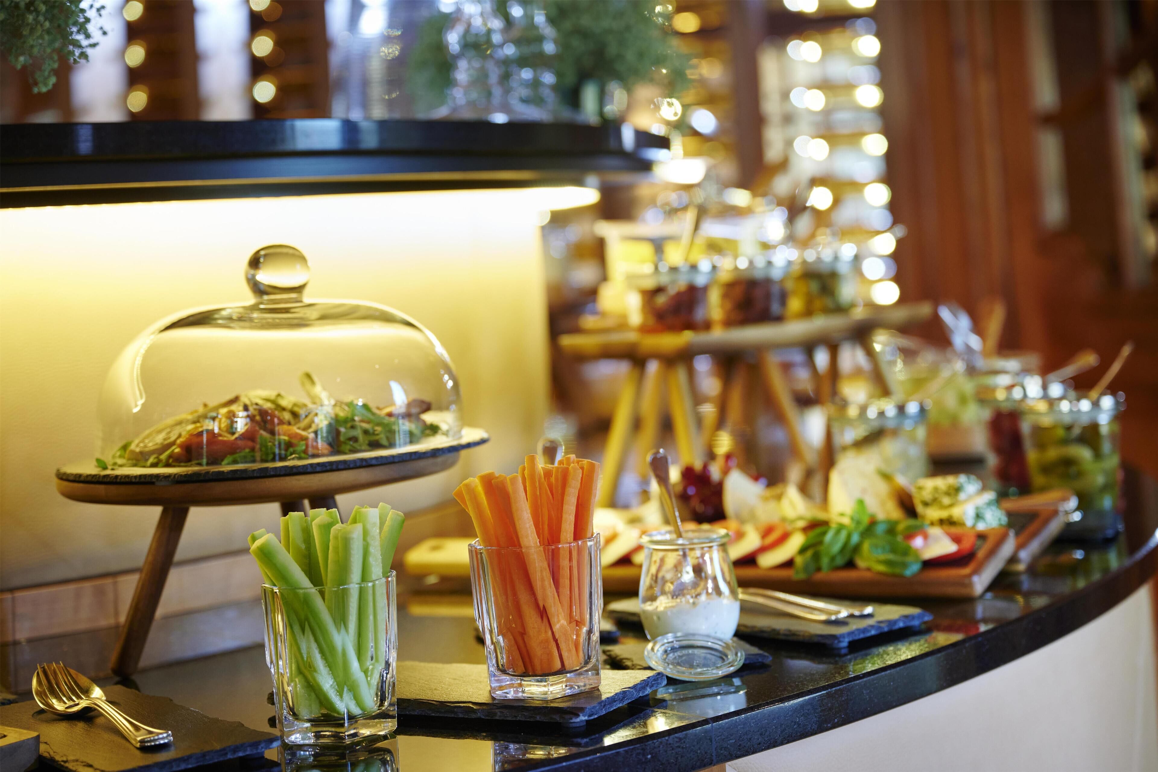 A buffet setup with various food items and utensils.