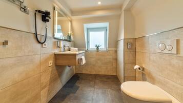 A modern bathroom with a toilet, sink, and mirror.