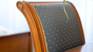 A wooden chair with a dark blue cushion featuring a dotted pattern.