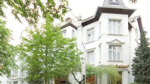 A white building with a prominent tower and multiple windows. - Hotel Spoettel (Bad Nauheim)