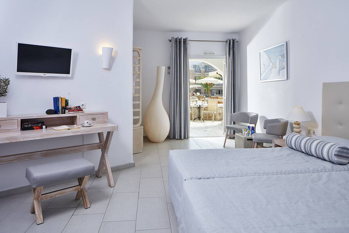 Ein modernes Hotelzimmer mit Bett, Schreibtisch und Sitzecke.