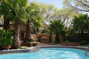 Una piscina al aire libre, sillones reclinables de piscina