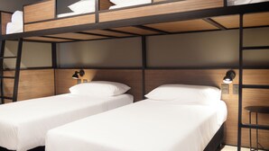 A bunk bed room with two single beds, a nightstand with a lamp, and a small table. - ibis Buenos Aires Congreso (Buenos Aires)