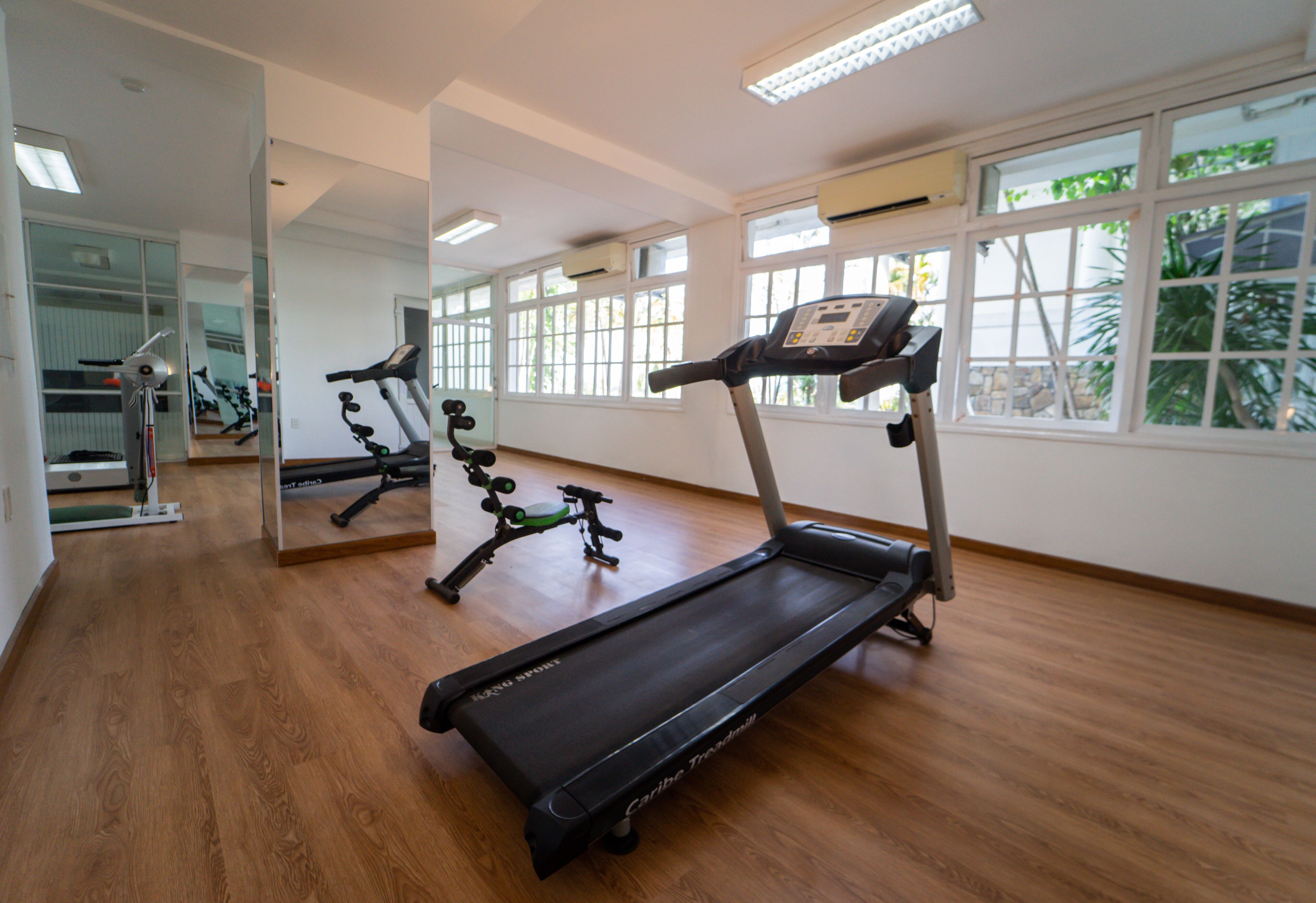 Ett gym med löpband, motionscykel och spegelbeklädda väggar.