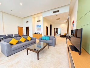 A spacious hotel lobby with a grey sofa set, a coffee table, and a flat-screen TV. - Holiday Inn Melaka by IHG (Malacca City)