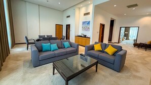 Ein geräumiger Wohnbereich mit zwei Sofas, einem Couchtisch und einer Küche im Hintergrund.