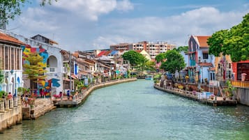 A canal lined with colorful buildings, a narrow waterway, and a bridge.