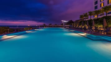 Una piscina al aire libre, sillones reclinables de piscina