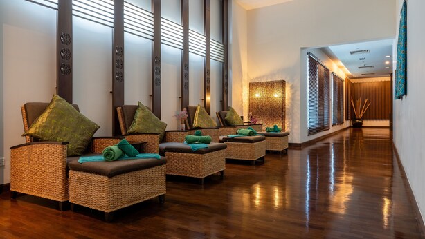 A spa area with wicker chairs, green towels, and a wooden floor. - Holiday Inn Melaka by IHG (Malacca City)