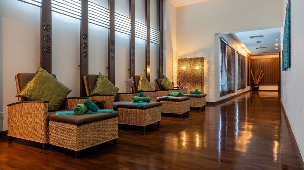 A spa area with wicker chairs, green towels, and a wooden floor. - Holiday Inn Melaka by IHG (Malacca City)