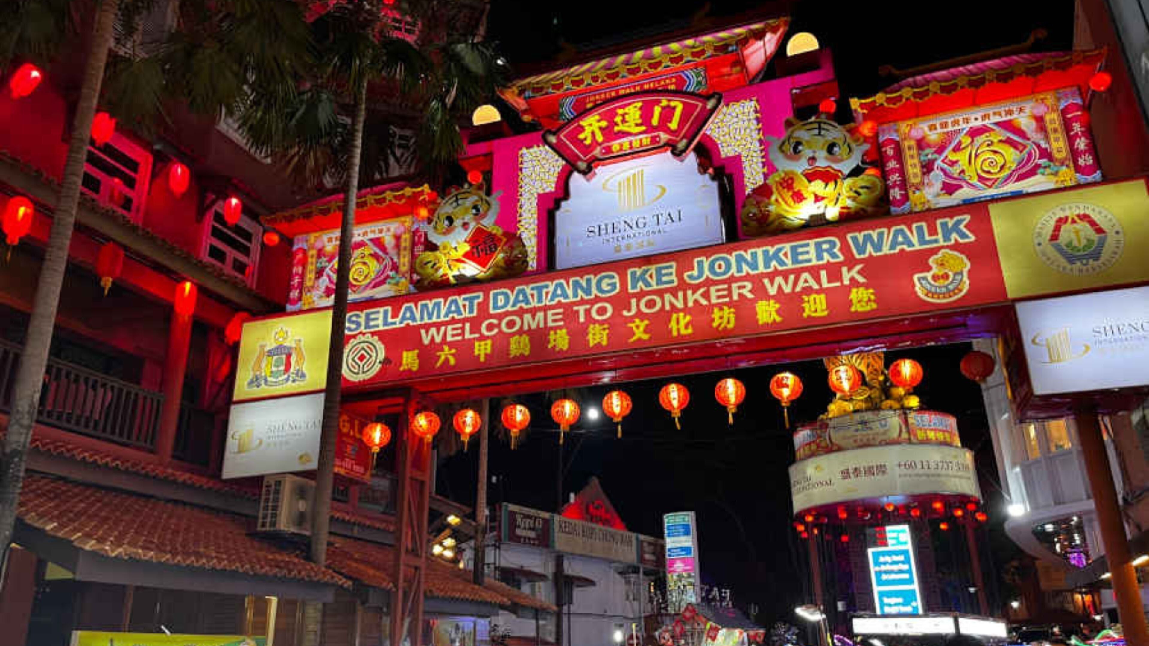 Una puerta tradicional china con letreros iluminados que dan la bienvenida a los visitantes a Jonkker Walk.